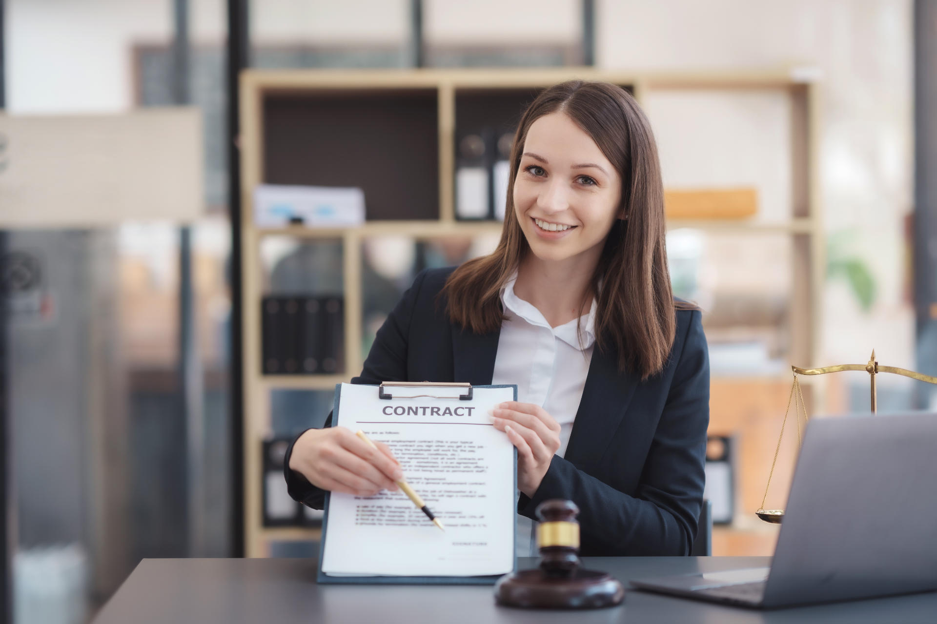 Female lawyer sitting happily working on laptop computer with ha