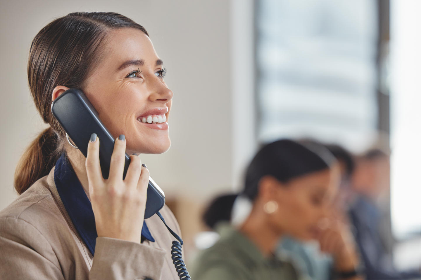 Shot of a young businesswoman talking on a telephone while worki