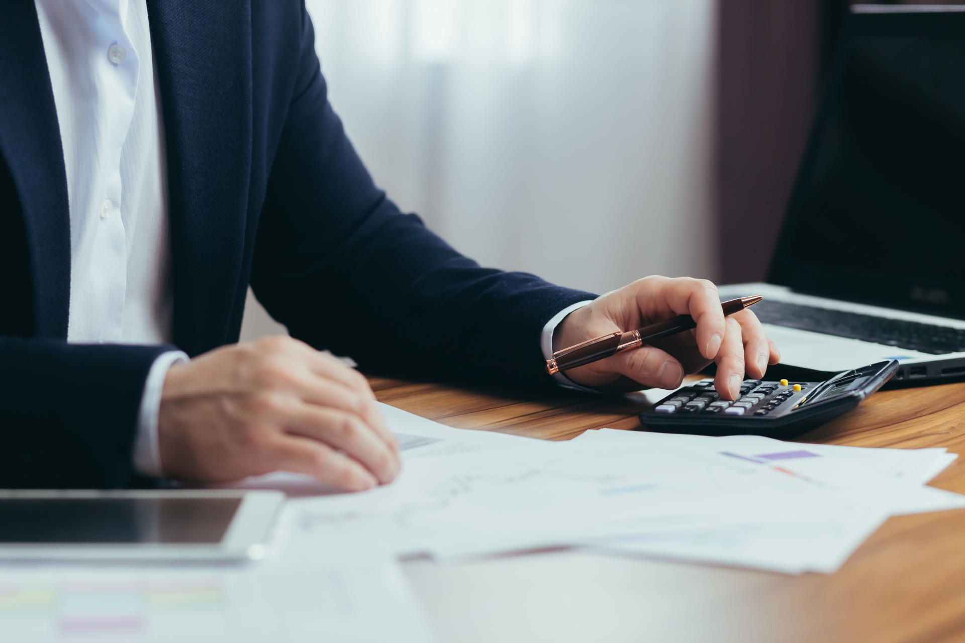 Close up photo, businessman accountant's hand counts on a calculator